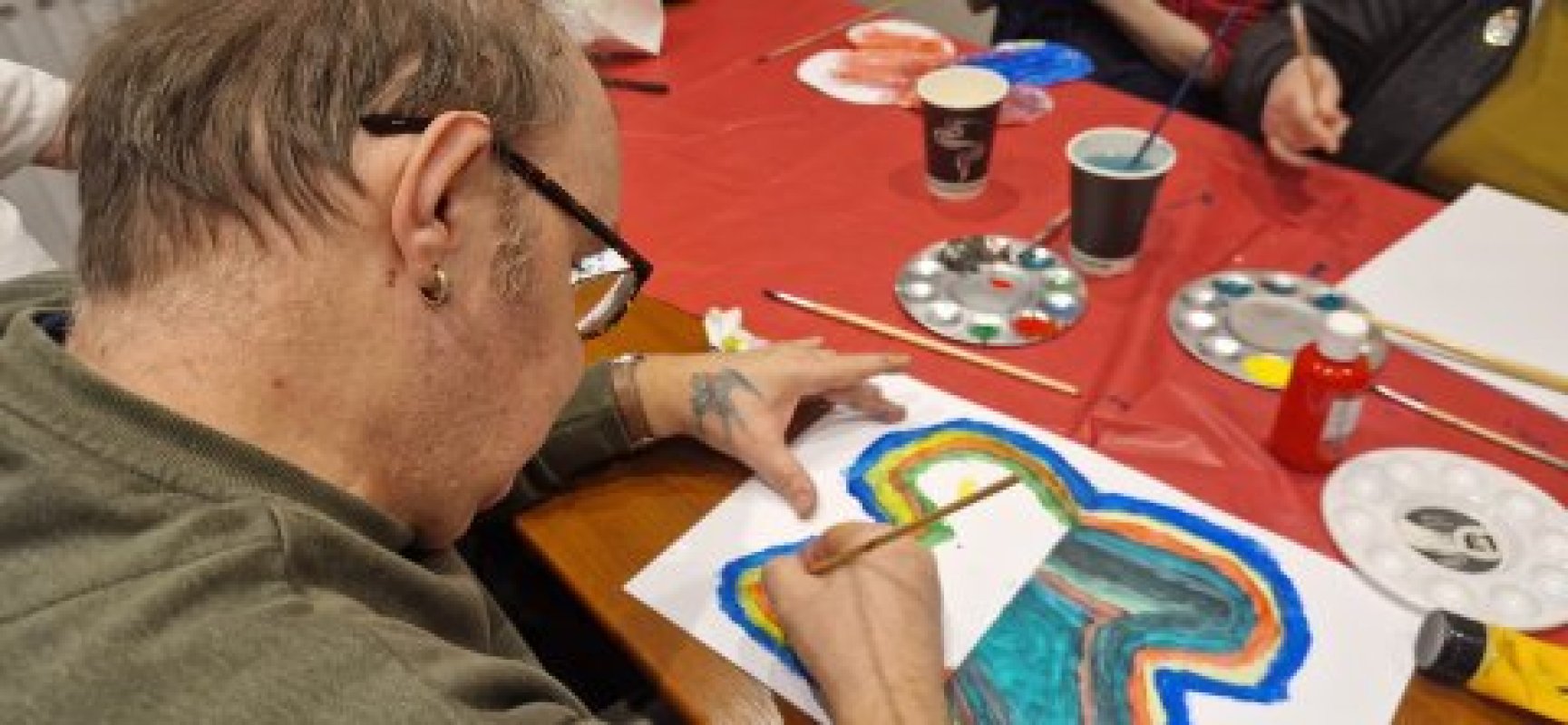 Close view of a man painting a large colour butterfly
