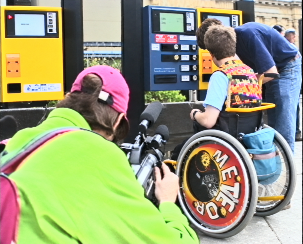 Camera filming two people and ones in a wheelchair