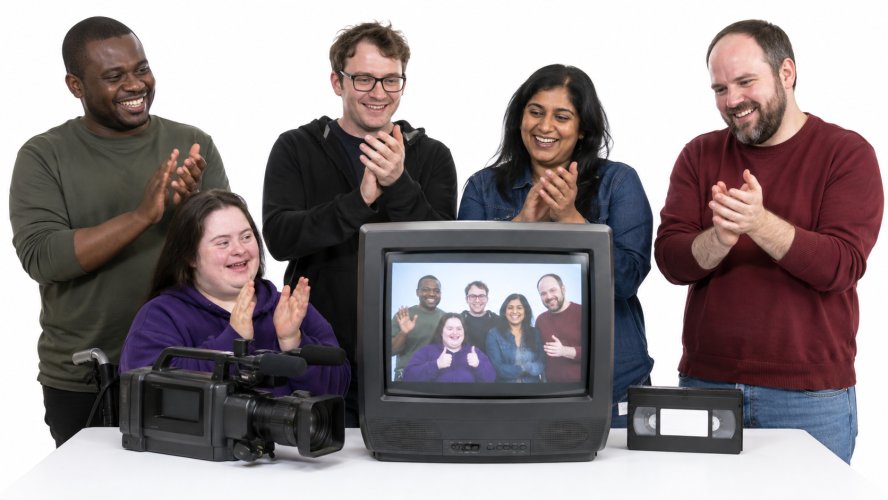 An adult learns to use a video camera on a tripod.