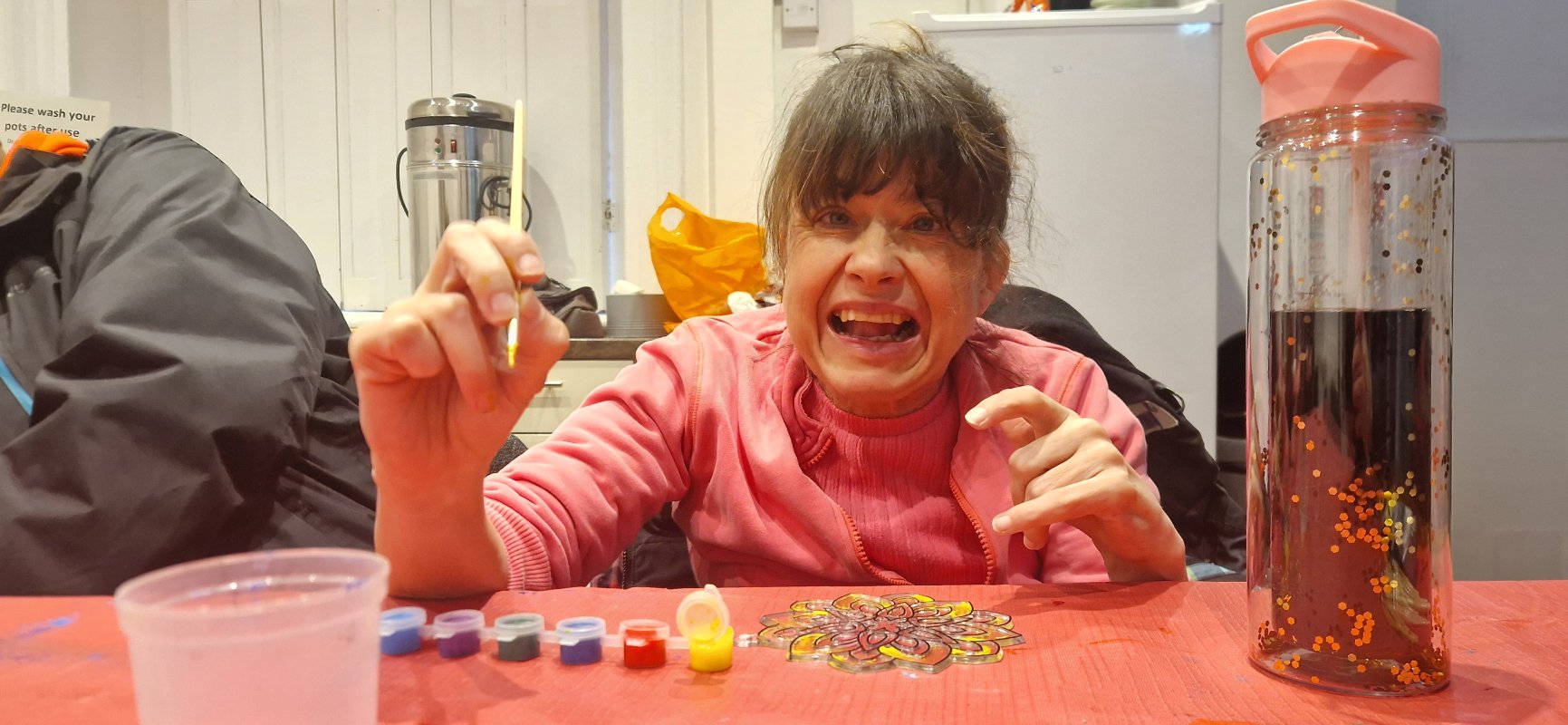 A Women in a wheelchair call lucy doing glass painting